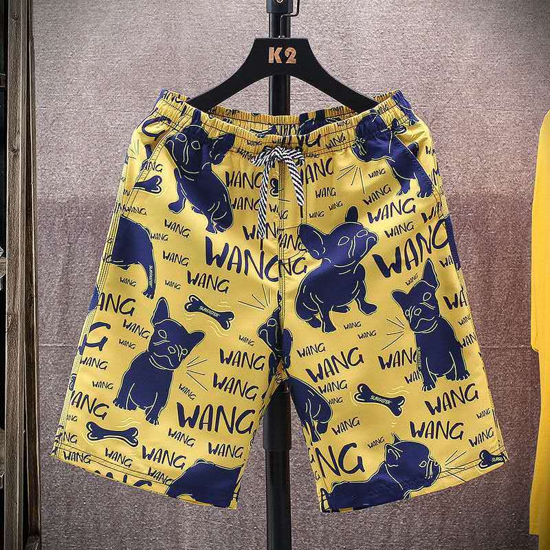Yellow men's beach shorts with blue dog and bone print, designed for a fun and casual summer look.