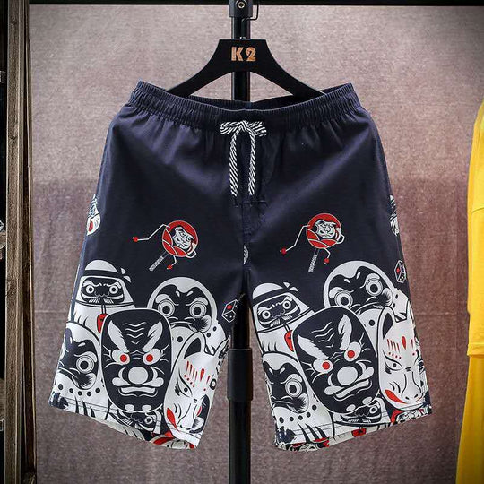 Men's beach shorts with traditional Japanese mask and Daruma doll prints, offering a unique and cultural summer style.