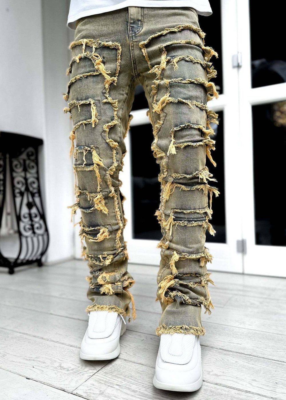 Men's stacked jeans in khaki with yellow distressed patches. Tight fit denim offering a bold and edgy streetwear look.