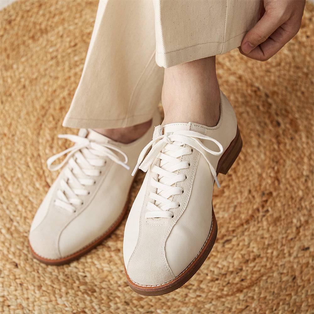 Men's vintage cowhide shoes worn with cream pants, highlighting the premium leather and comfortable platform design on woven mat.