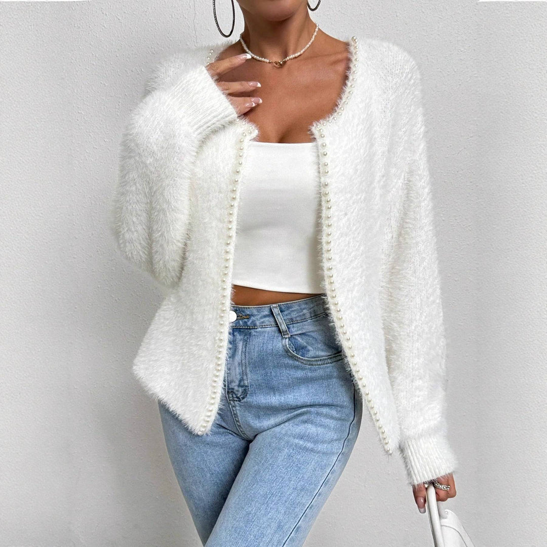 Women's Elegant V-Neck Bead Knitwear Cardigan Sweater in white polyester, styled with jeans for a chic casual look. Features pearl bead trim detail.