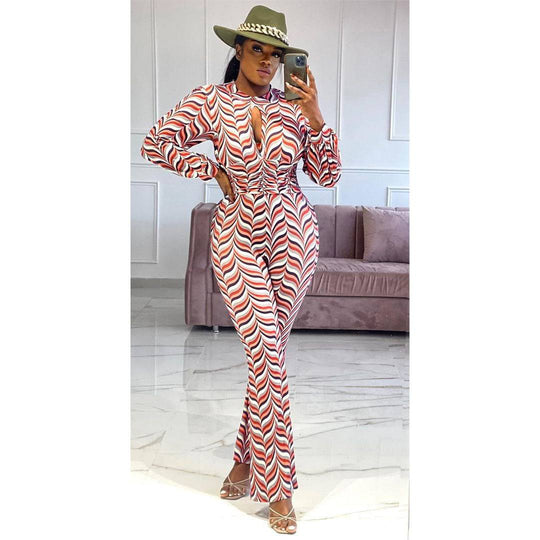Model wearing Smocked Print Flared Jumpsuit with cutout nipped waist, posing indoors to showcase the flattering high waist and flared silhouette.